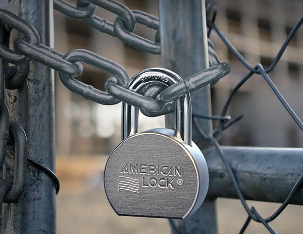 An American Lock Padlock secured to a chain link fence in Vancouver, BC