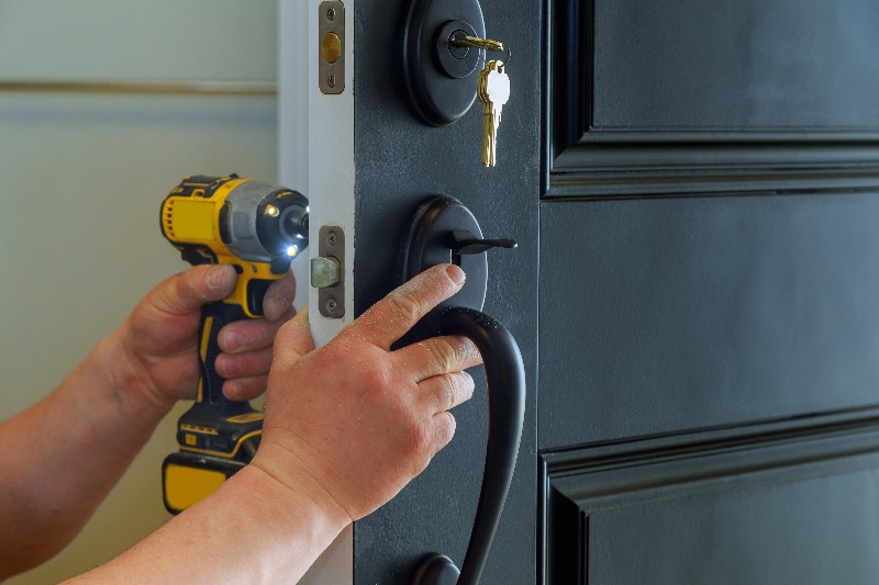 Professional locksmith installing or repairing a new deadbolt lock for residential home in Vancouver, BC
